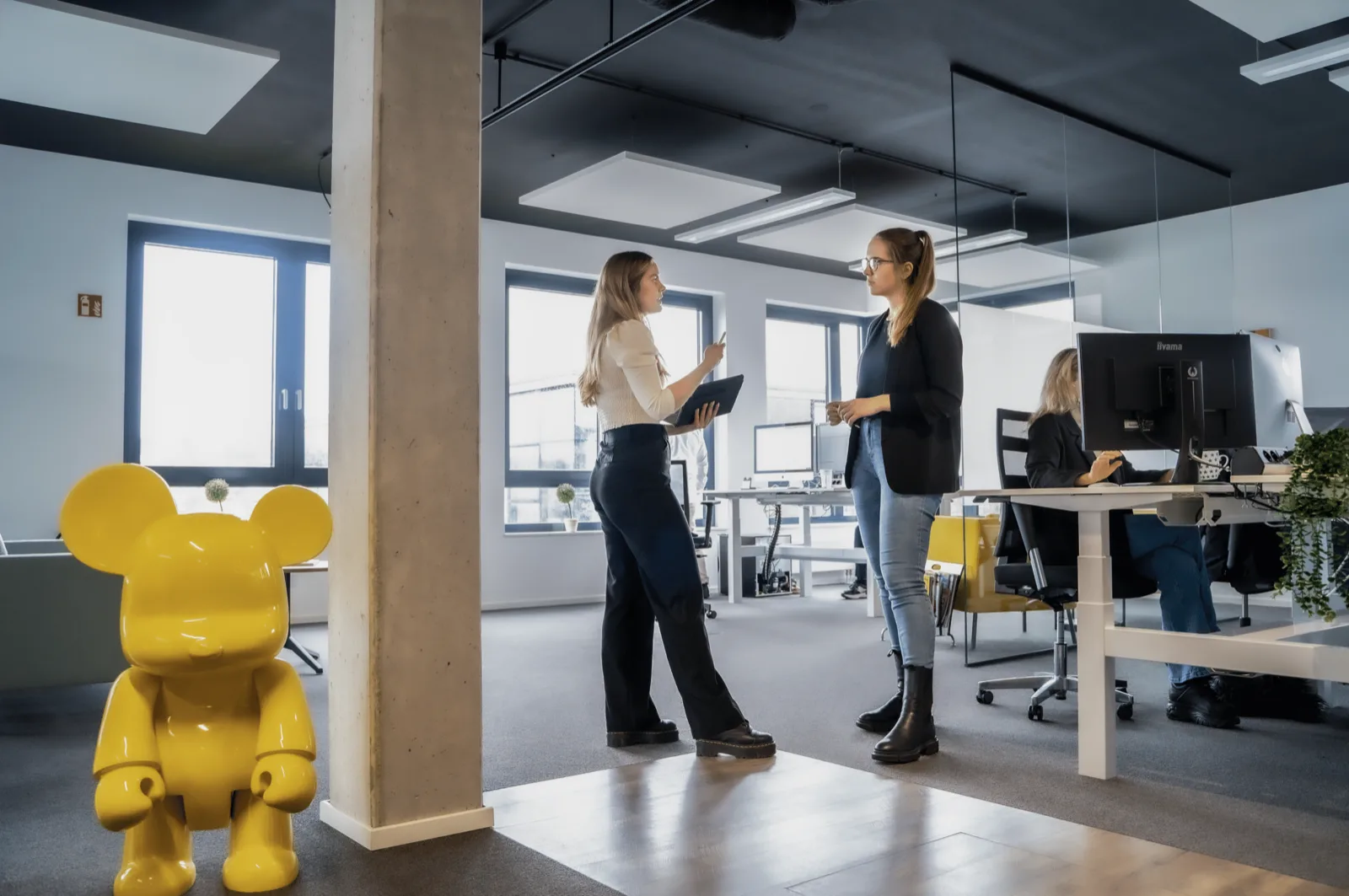Zwei Mitarbeiterinnen von SUMAX im Gespräch im Büro