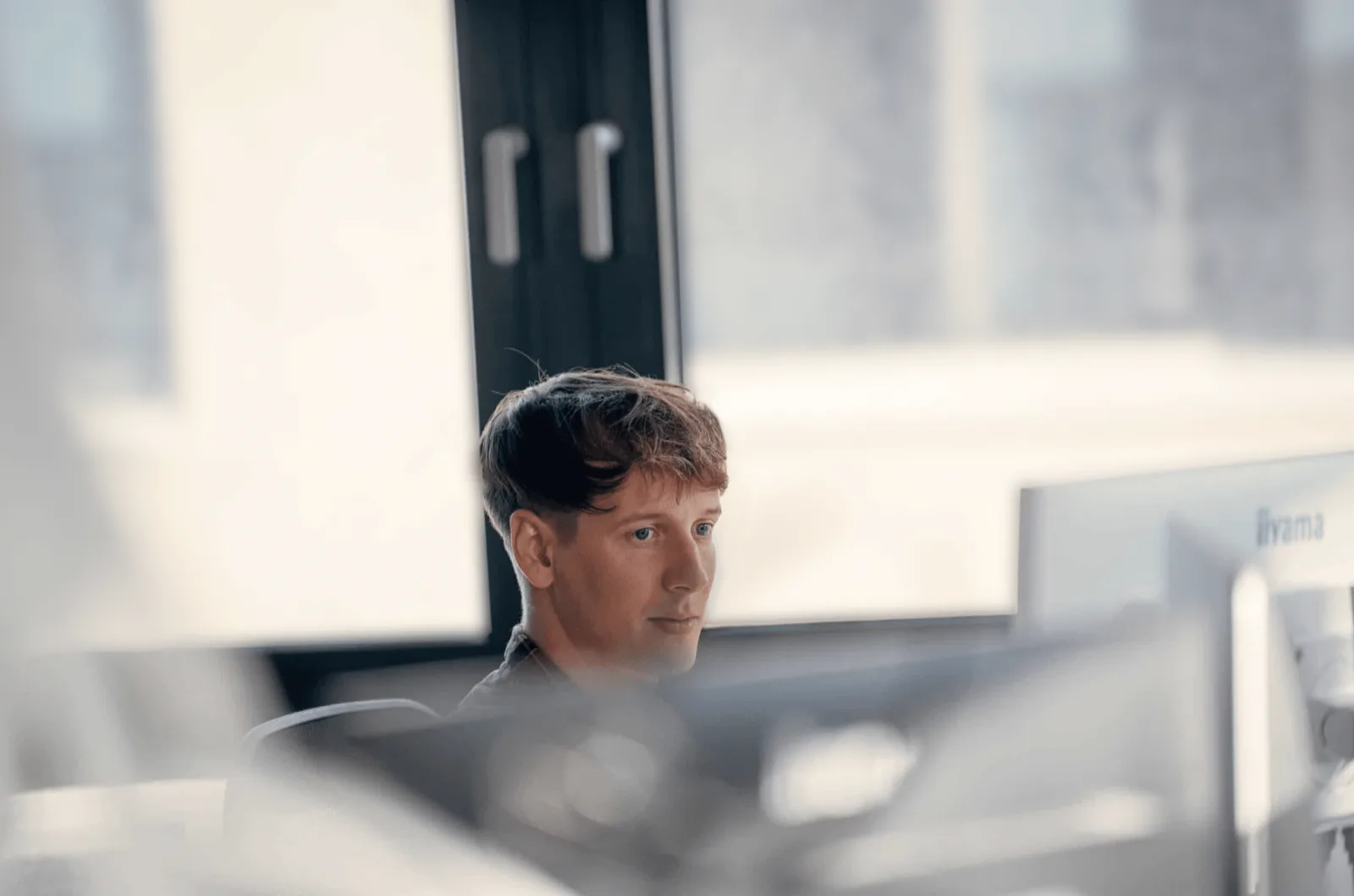 Mitarbeiter von SUMAX arbeitet konzentriert am Fenster